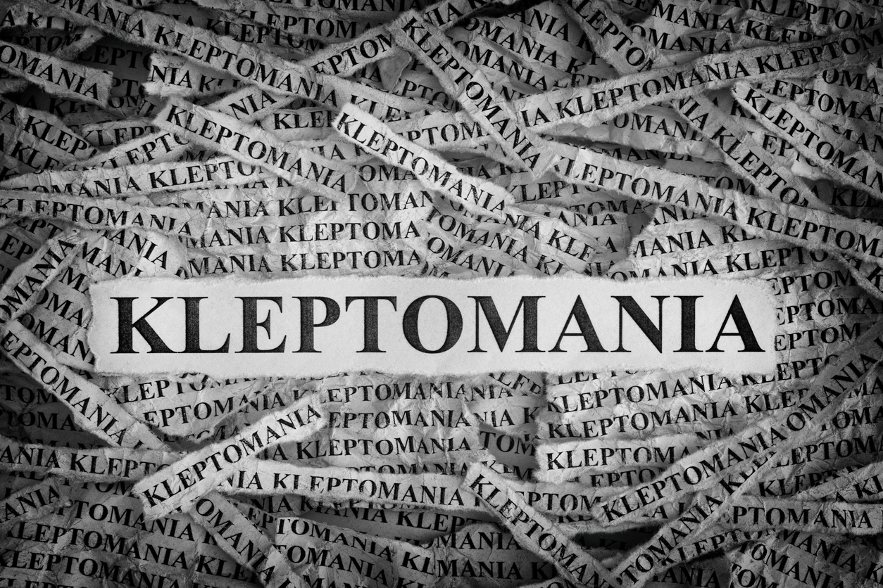 Kleptomania. Torn pieces of paper with the words Kleptomania. Concept Image. Black and White. Closeup.what-is-kleptomania