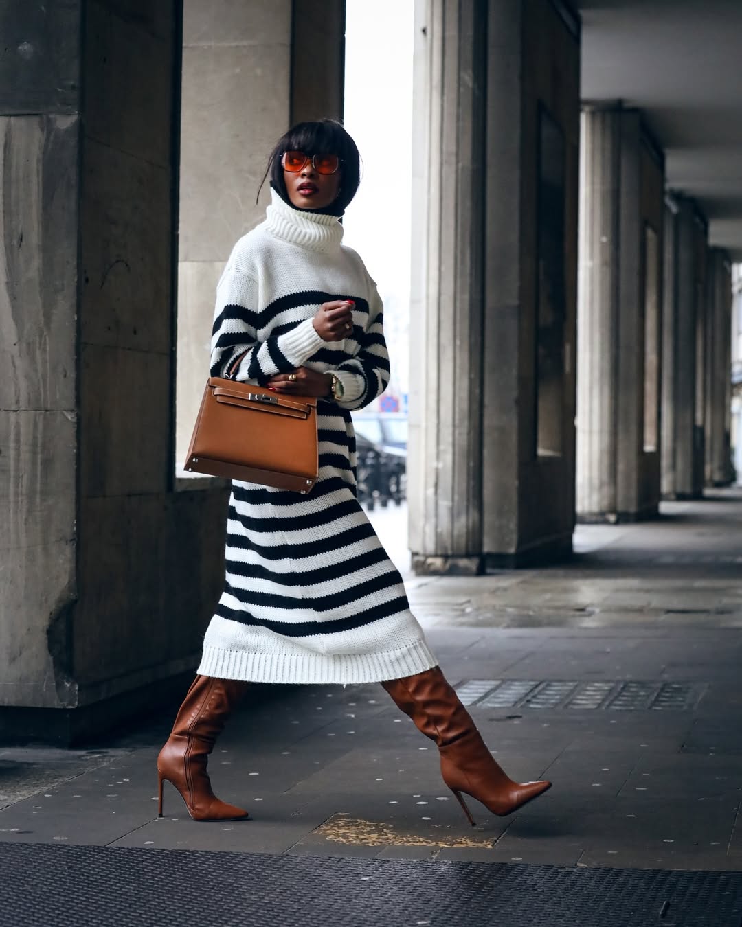 Женщина в скромном свитере с кожаными сапогами