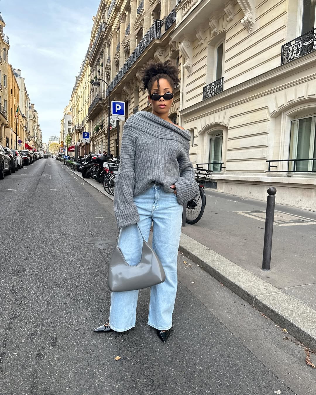 Женщина в свитере с открытыми плечами, широких джинсах и ботильонах в осенний день — шикарные идеи наряда с открытыми плечами