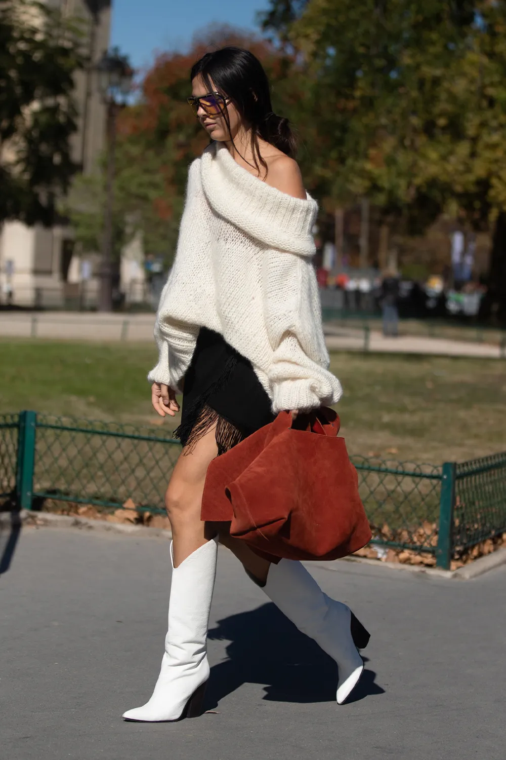 Свитер с напуском и открытыми плечами в сочетании с черной юбкой и белыми ботильонами.