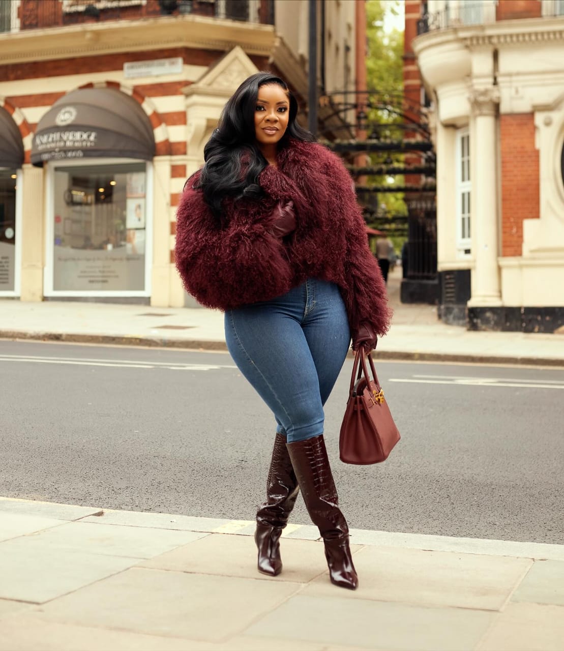 женщина в облегающих джинсах, осенних ботинках и меховой куртке