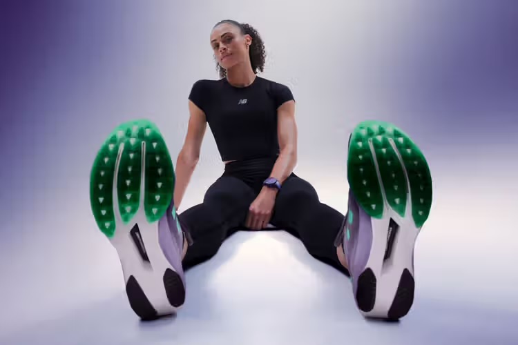 Модель с подключенным калибром Tag Heuer E5 X New Balance Edition SmartWatch и кроссовками Fuelcell Supercomp Elite V5.