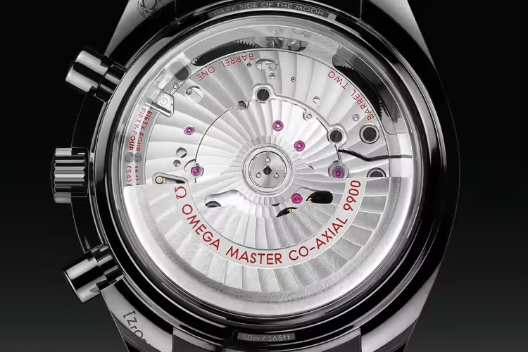 Крупным планом задняя часть серых часов: корпус из полированной нержавеющей стали, выгравированный логотип бренда и точные детали ручной работы.