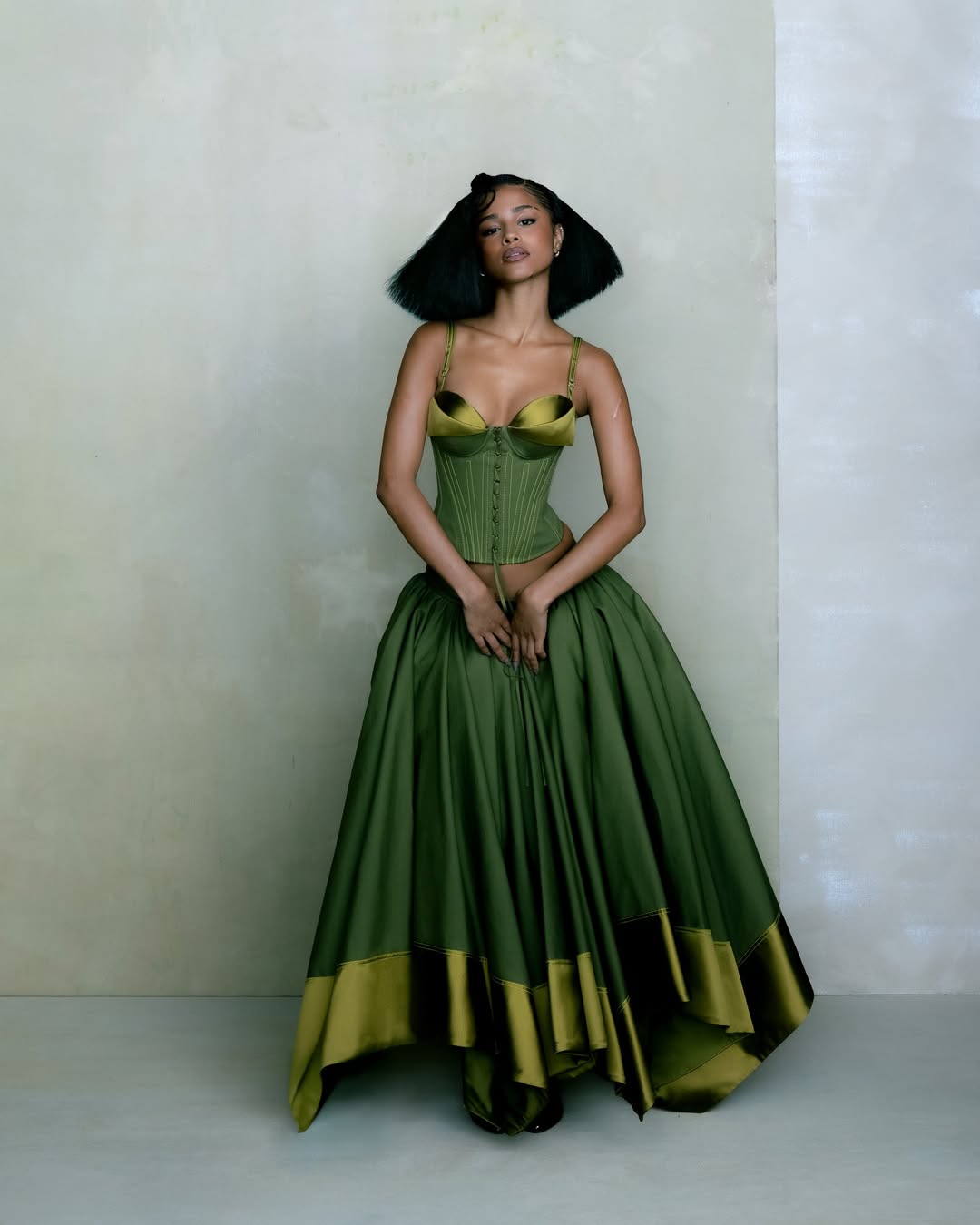 Тайла в топе и юбке Christopher John Rodgers в сочетании с туфлями Christian Louboutin и серьгами-кольцами Pandora.