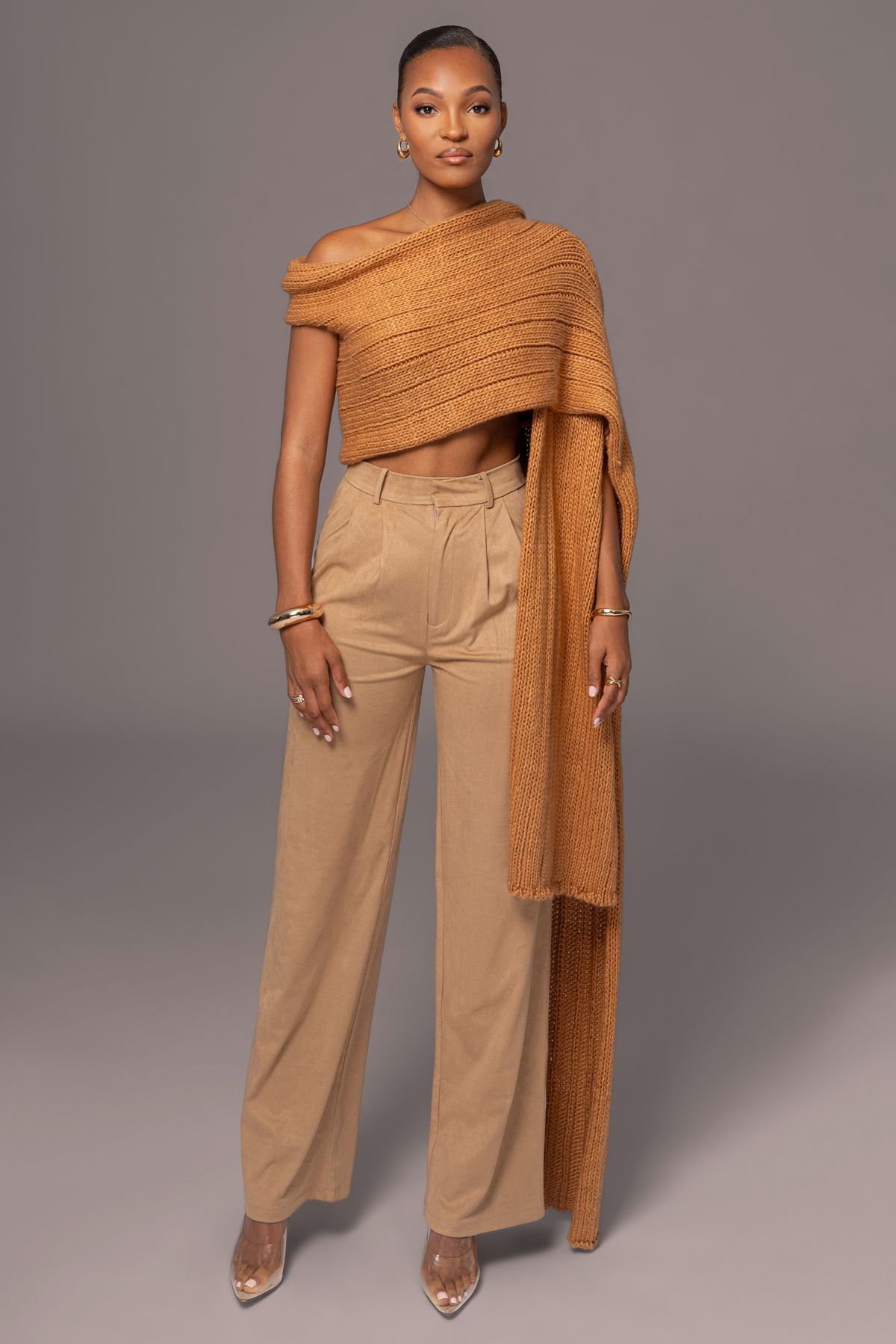 Модель в свитере с открытыми плечами, строгими брюками и золотыми украшениями — идеи свитера с открытыми плечами.