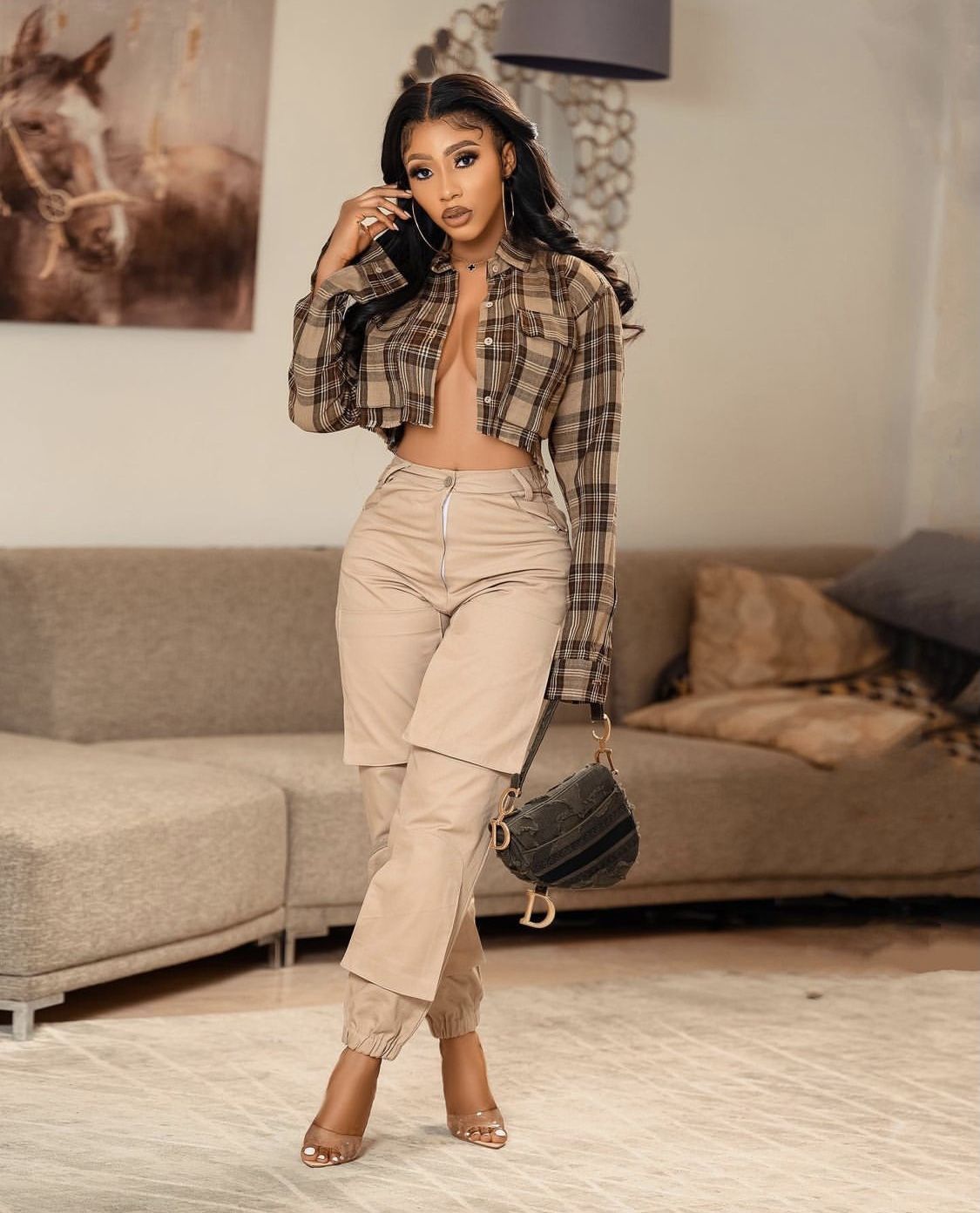Женщина в брюках цвета хаки и рубашке на шпильках демонстрирует шикарные женские наряды в брюках цвета хаки и на каблуках.