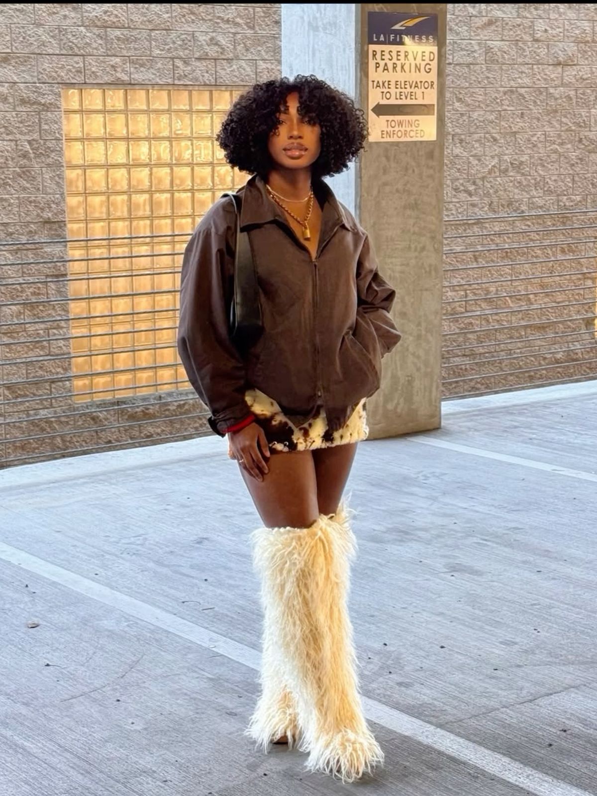 женщина в меховых сапогах осенью с курткой и мини-юбкой