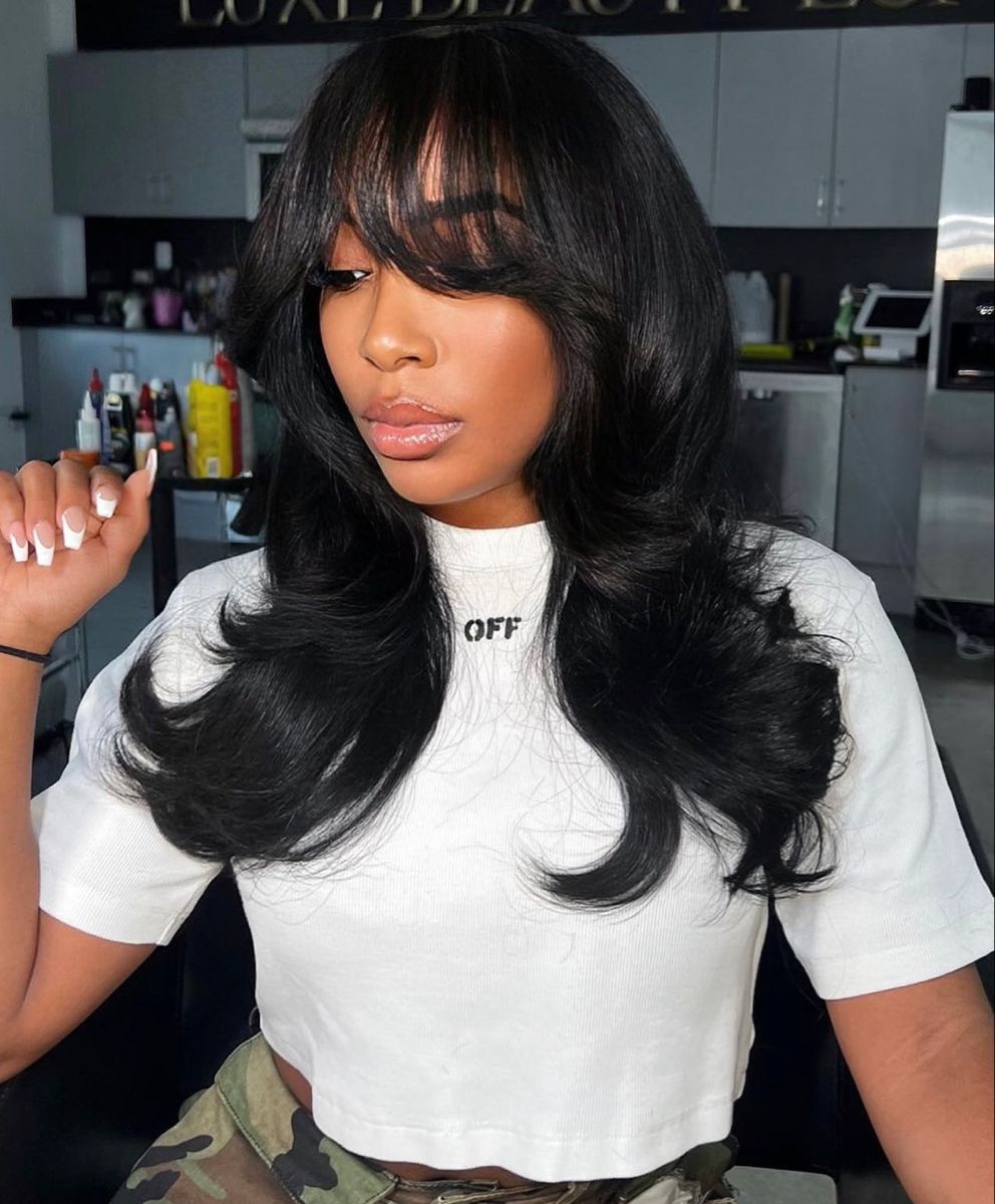 Shoulder-length haircut featuring long, face-framing bangs and loose waves — trending medium length haircuts for women