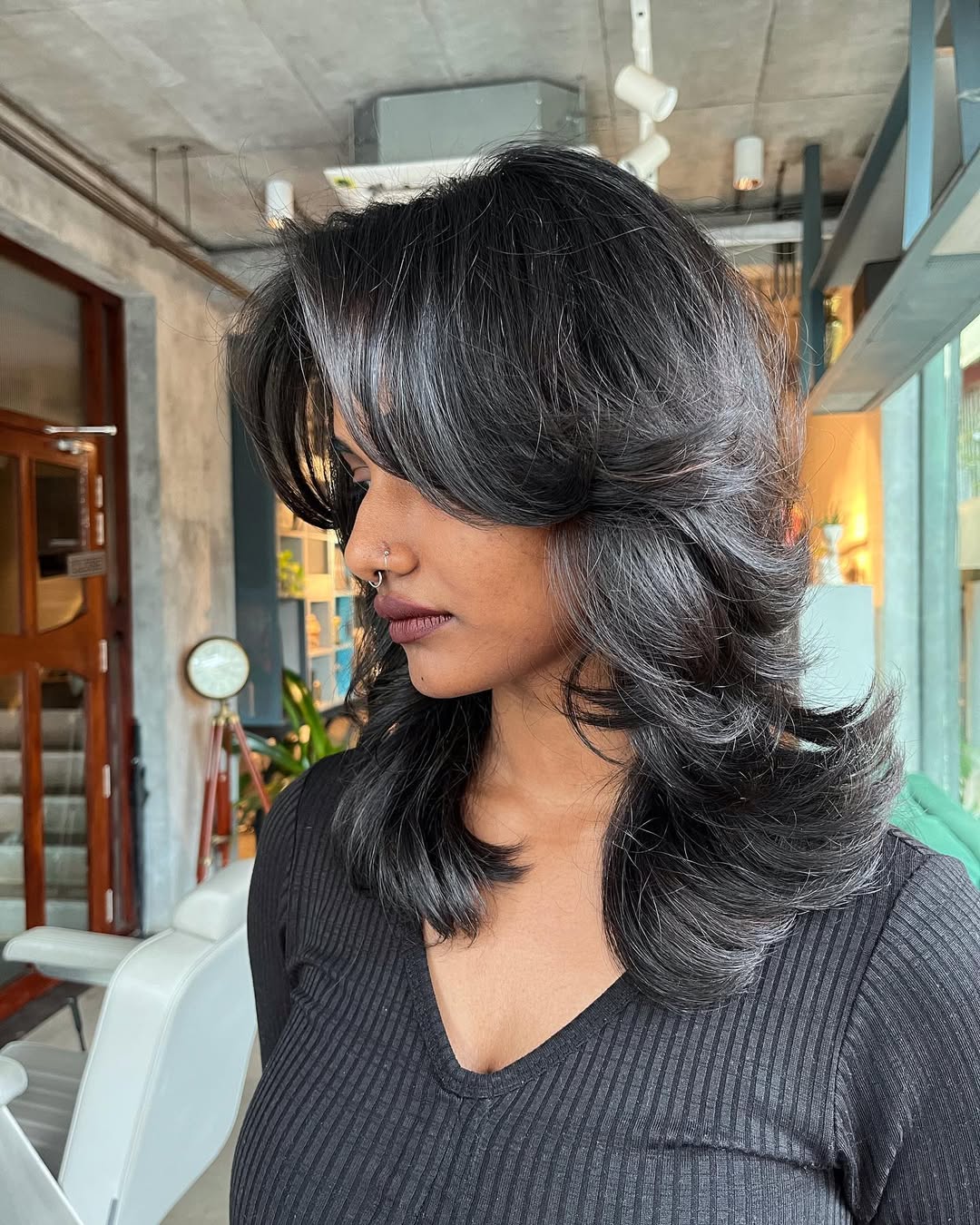 Textured medium shag haircut with wispy bangs and natural highlights — trending medium length haircuts for women