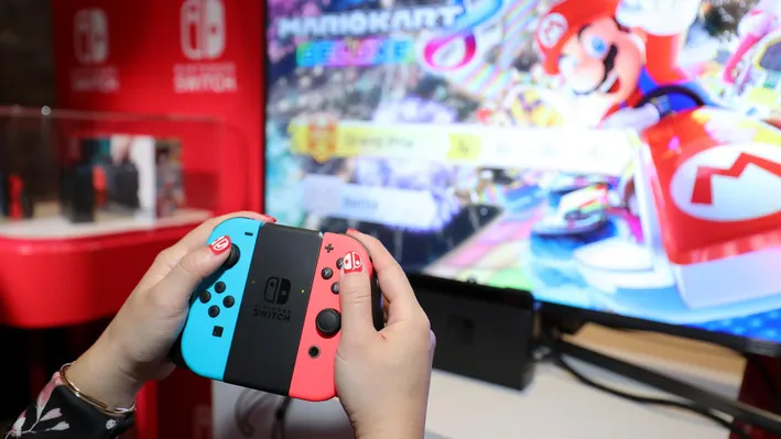 Player holding Nintendo Switch 2 console.