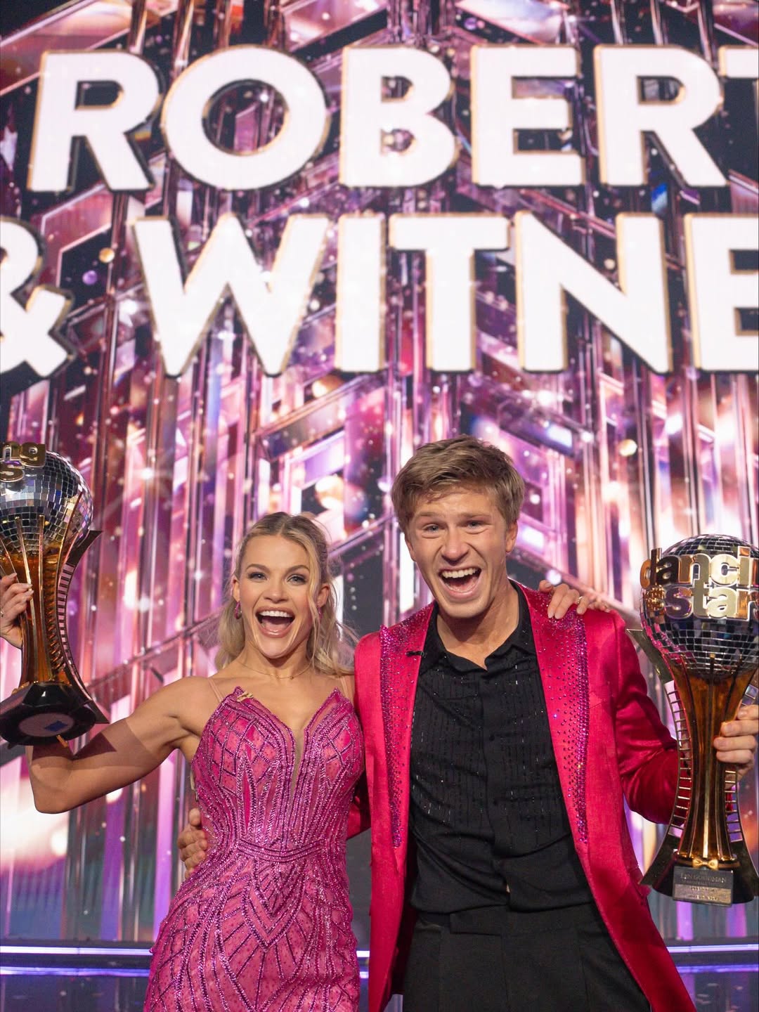 Robert Irwin and Witney Carson holding the Len Goodman Mirrorball trophy after winning Dancing With the Stars Season 34