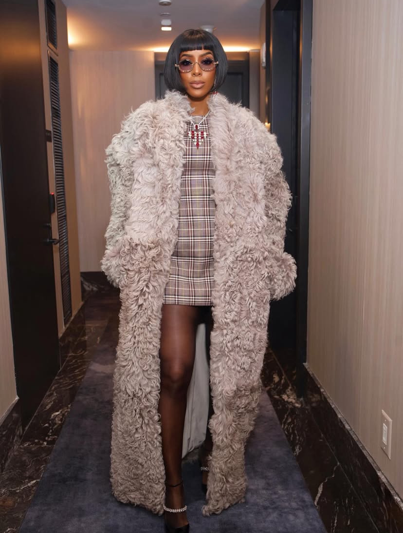 Kelly Rowland in a shaggy fur coat minimalist white look styled as a powerful, modern celebrity Thanksgiving outfit inspiration.