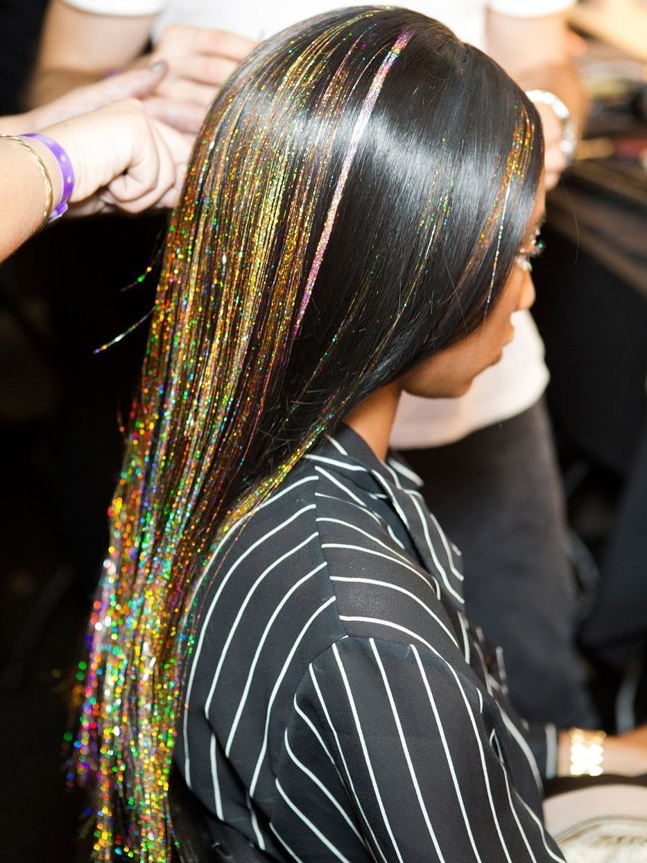 Металлизированные пряди крупным планом, подчеркивающие моду на мишуру для волос