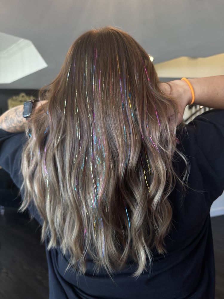 Тенденция мишуры для волос наносится на волнистую текстуру волос