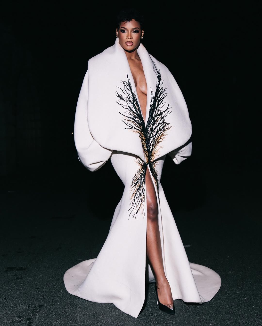 Диди Стоун в белом платье и черных туфлях