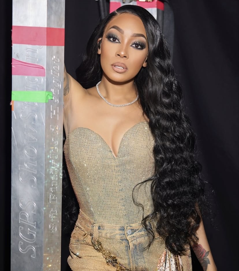 Monica Denise wearing a bold smoky eye with dark shadow, sharp eyeliner, long lashes, defined brows, and a neutral glossy lip — Franca Fund Gala