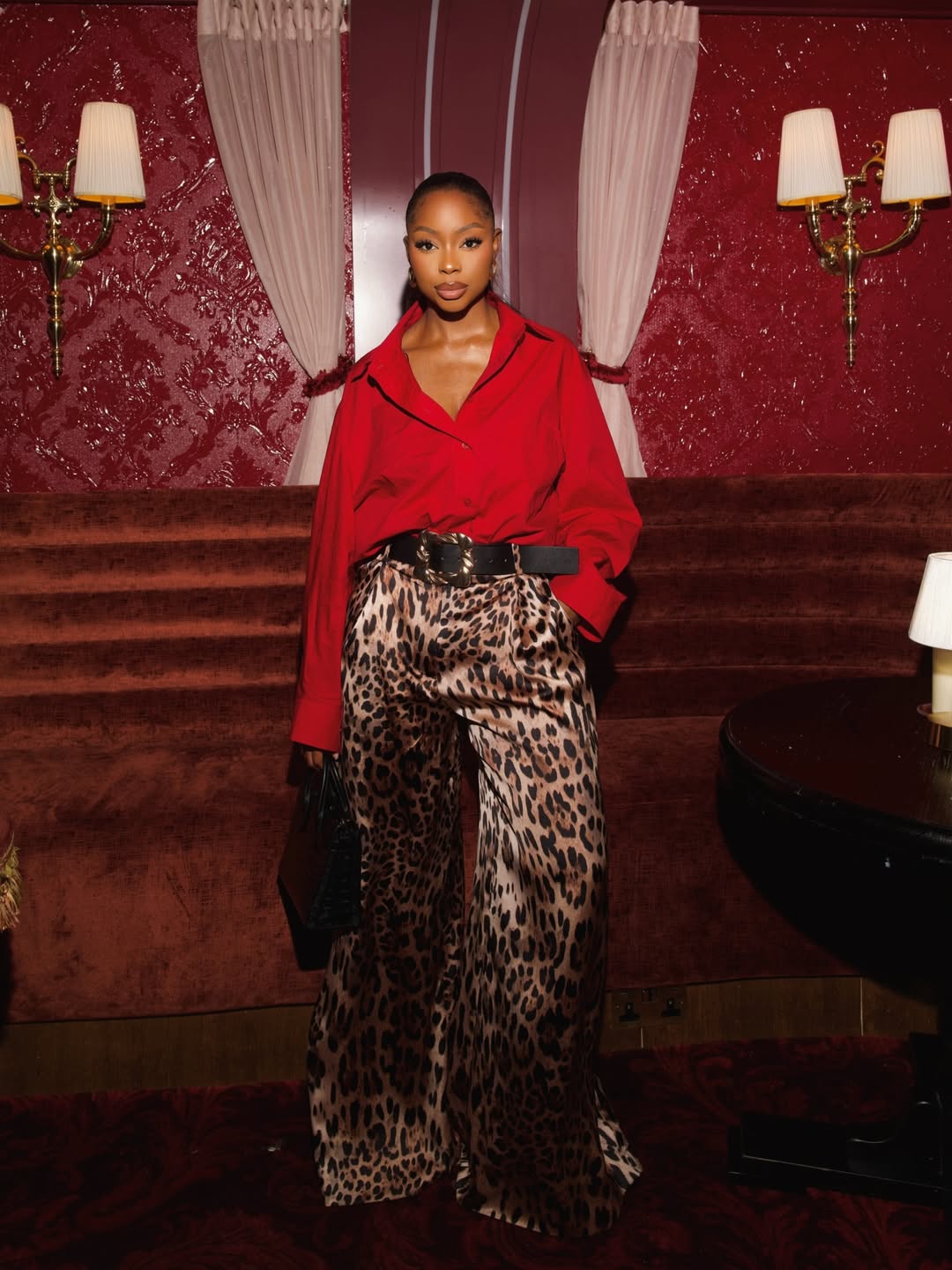 woman wearing festive outfit of red shirt and leopard print pants