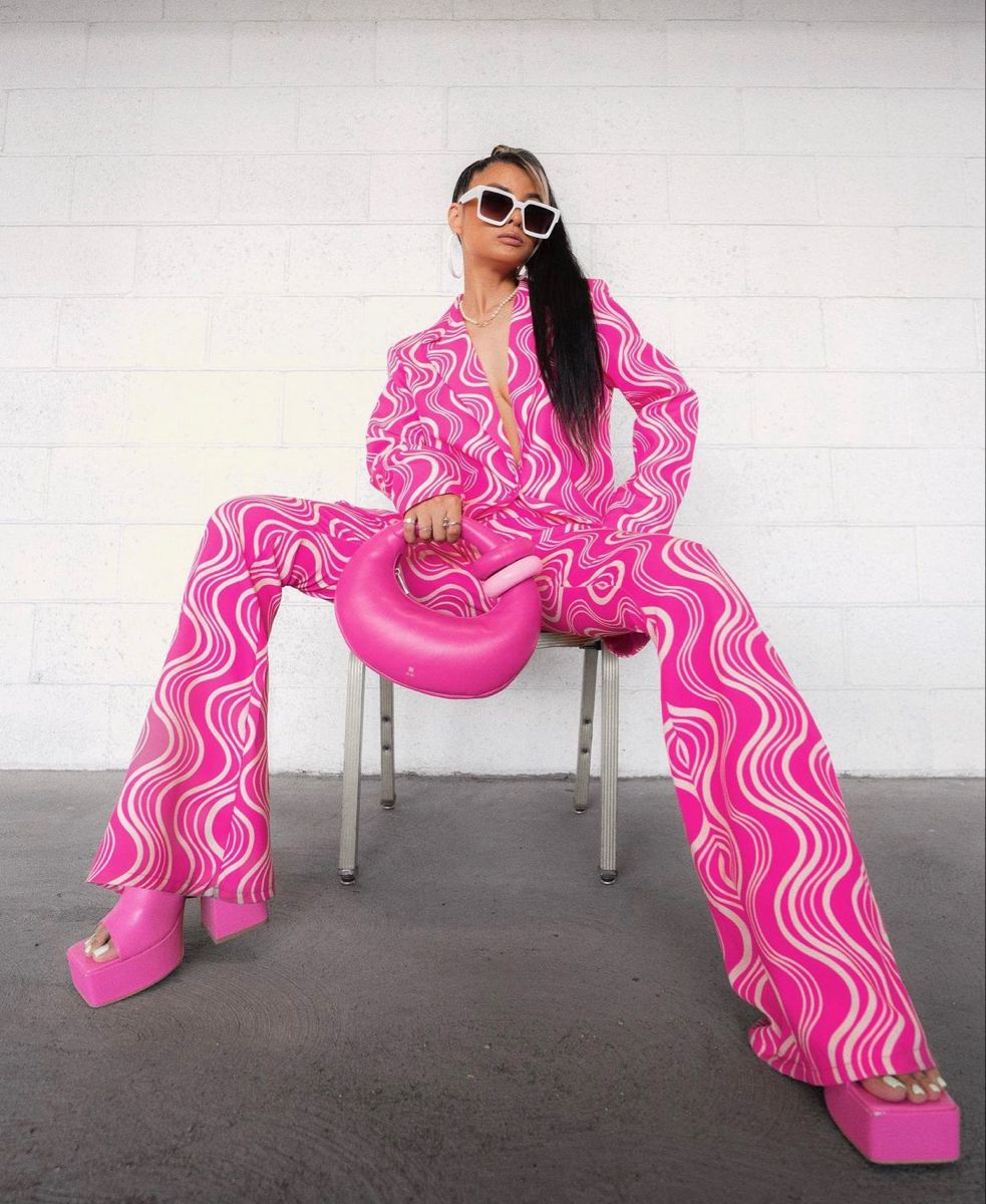 женщина в брюках с принтом и розовой туфлей