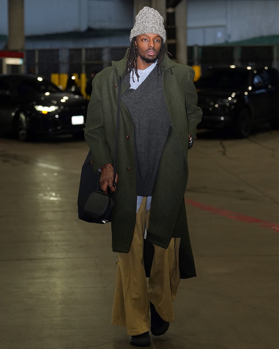 Мужчина носит многослойную зимнюю одежду с такими аксессуарами, как шапка 