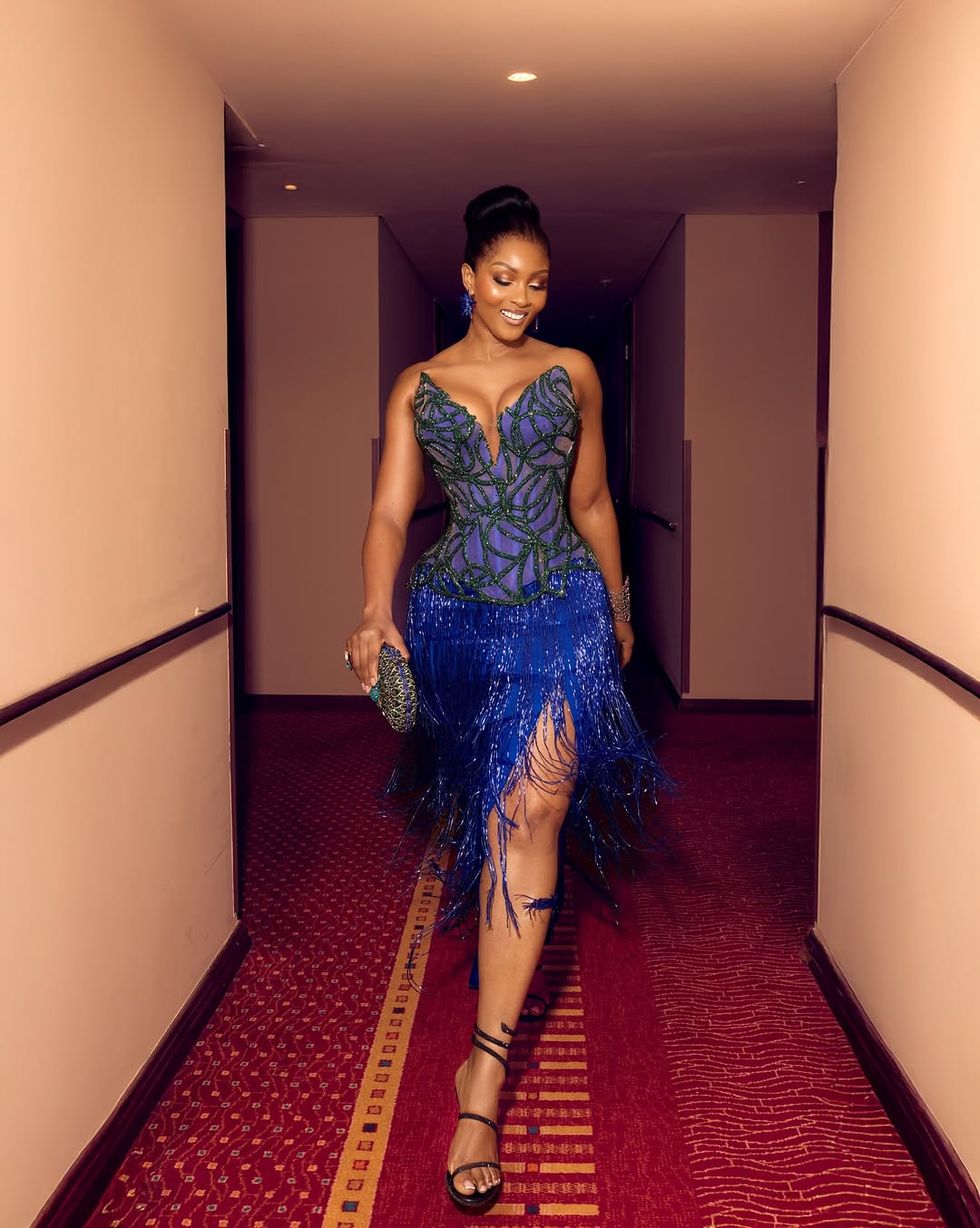 Осас носит синее платье с бахромой, как модница из Лагоса