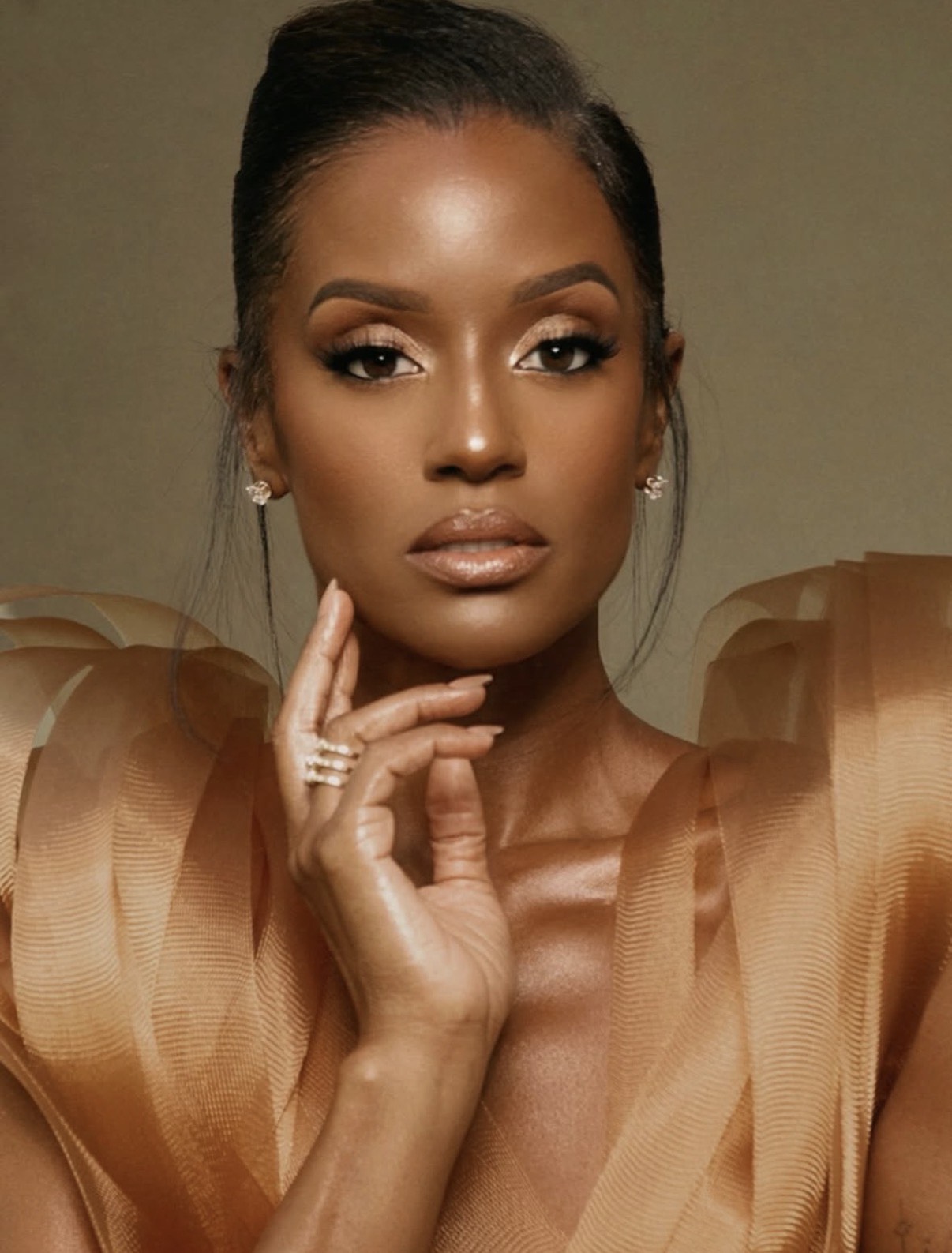 Skye Marshall showcasing golden glam makeup with shimmering gold eyeshadow, contoured skin, and glossy nude lips at the Golden Globes beauty lineup