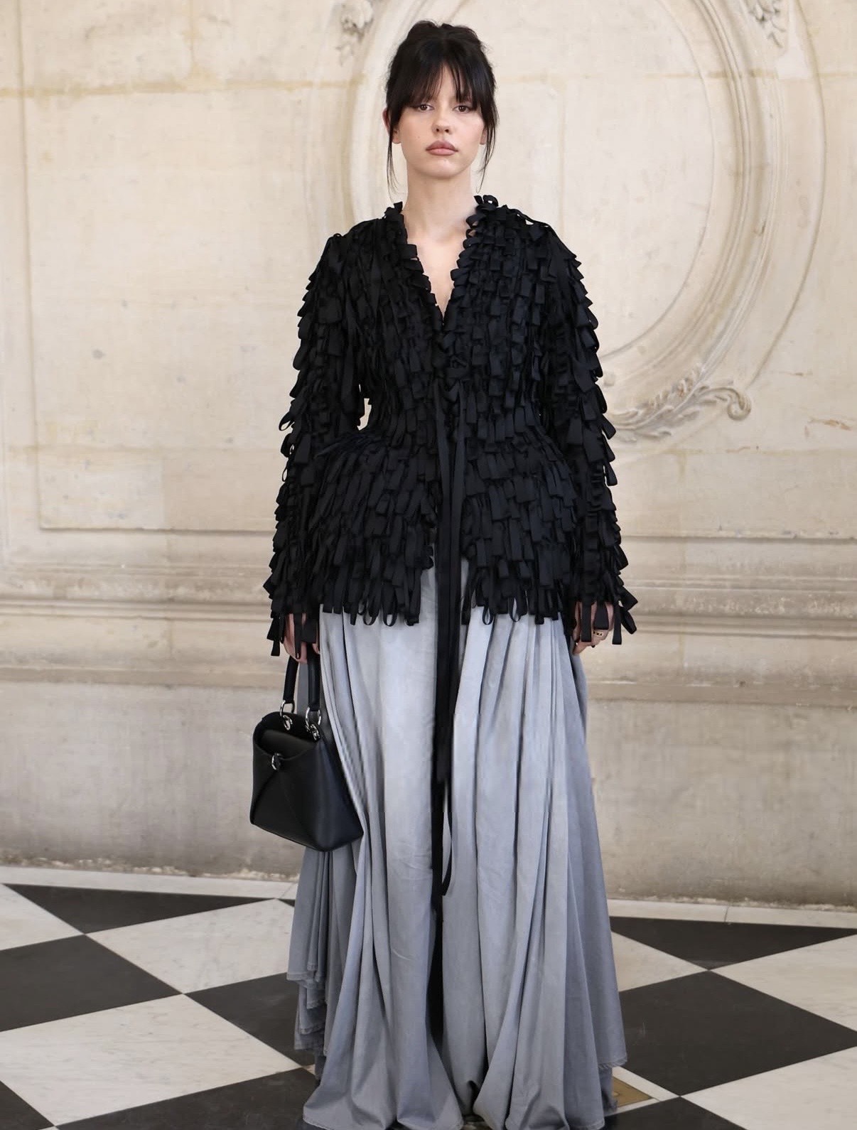 Mia Goth in a textured black ruffled top paired with a flowing grey skirt, highlighting avant-garde modern celebrity style 2026.