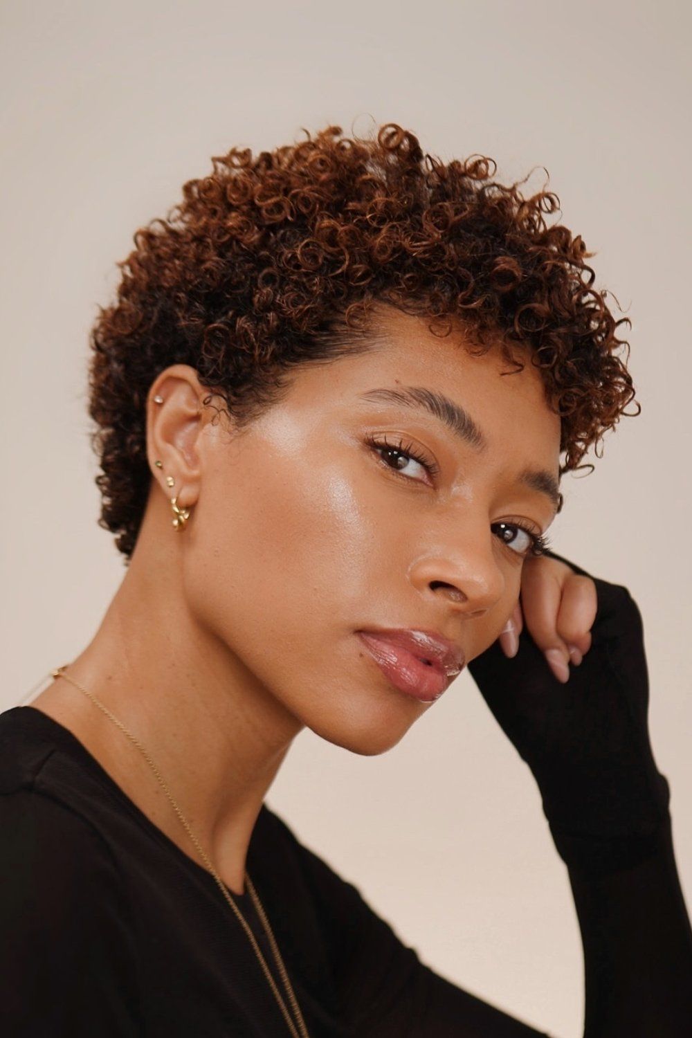 Короткая натуральная прическа в стиле афро с завитком пальца, подчеркивающая завитки