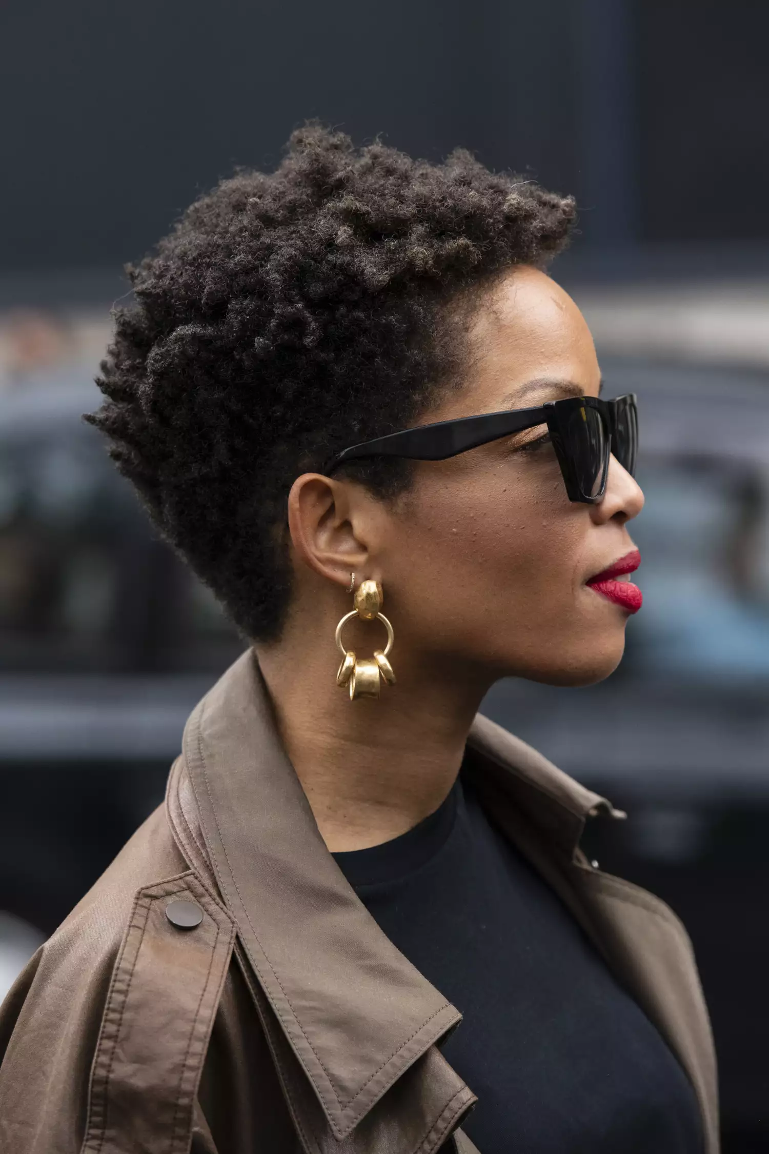 Короткая зауженная естественная прическа афро с четко очерченной макушкой и чистыми боками.