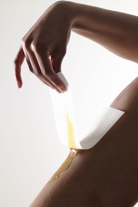 женщина натирает кожу воском дома