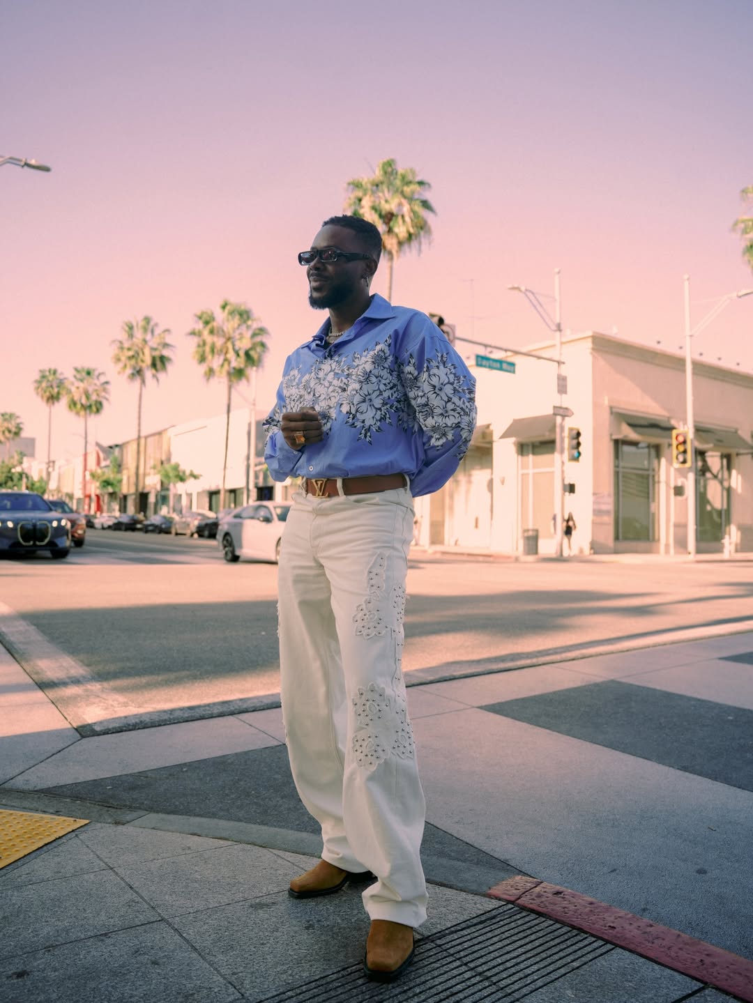 Adekunle Gold in a Spring Summer 2026 shirt with suede boots and statement accessories in elevated street style.