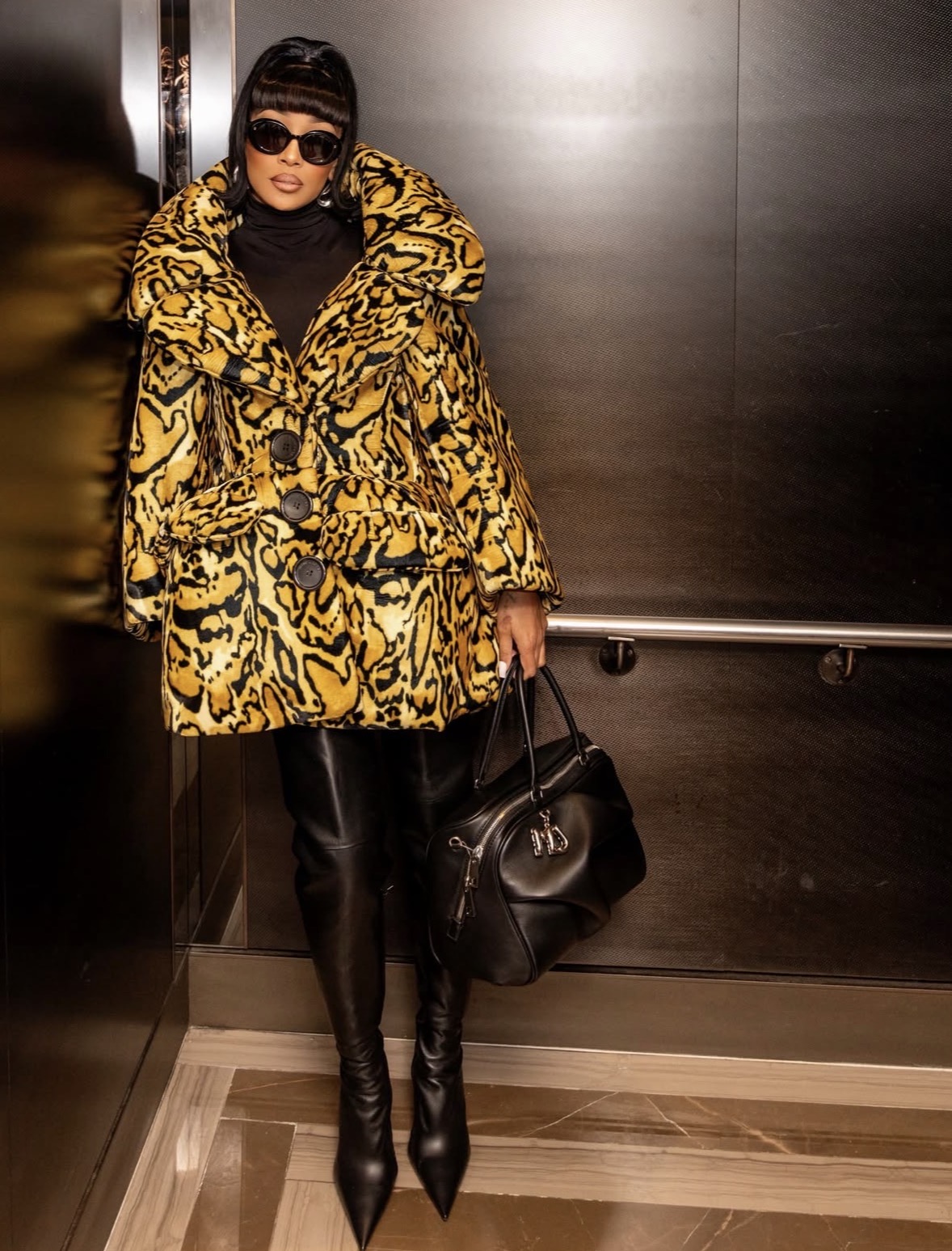 Monica Denise is wearing an oversized animal-print Marc Jacobs coat and leather leggings at the 2026 New York Fashion Week styles shows, presenting a dramatic outerwear statement.