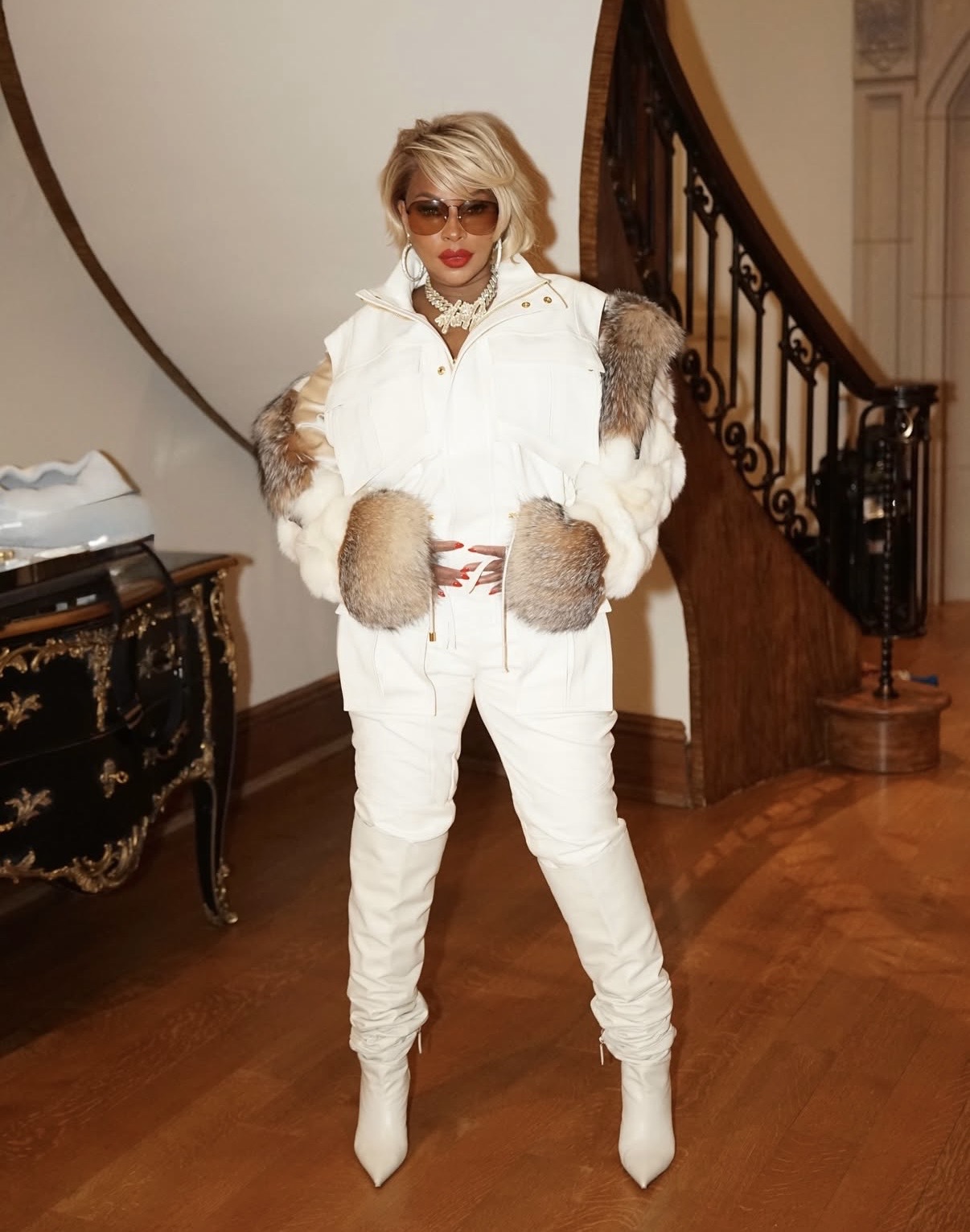 Mary J. Blige in a monochromatic white puffer vest with faux fur details, slim trousers, and thigh-high boots styled with statement jewelry— Edgy celebrity outfits