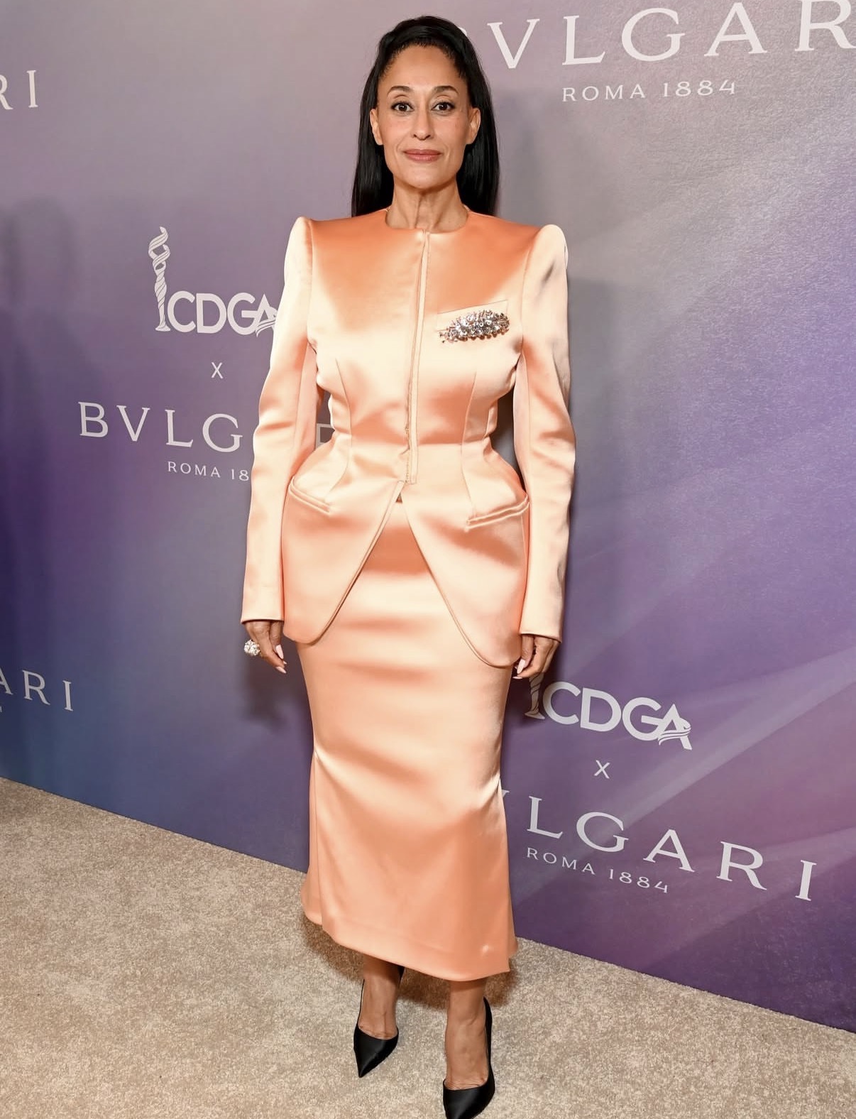 Tracee Ellis Ross wearing a peach satin Mugler two-piece with sculpted shoulders and a fitted pencil skirt at the Costume Designers Guild Awards.