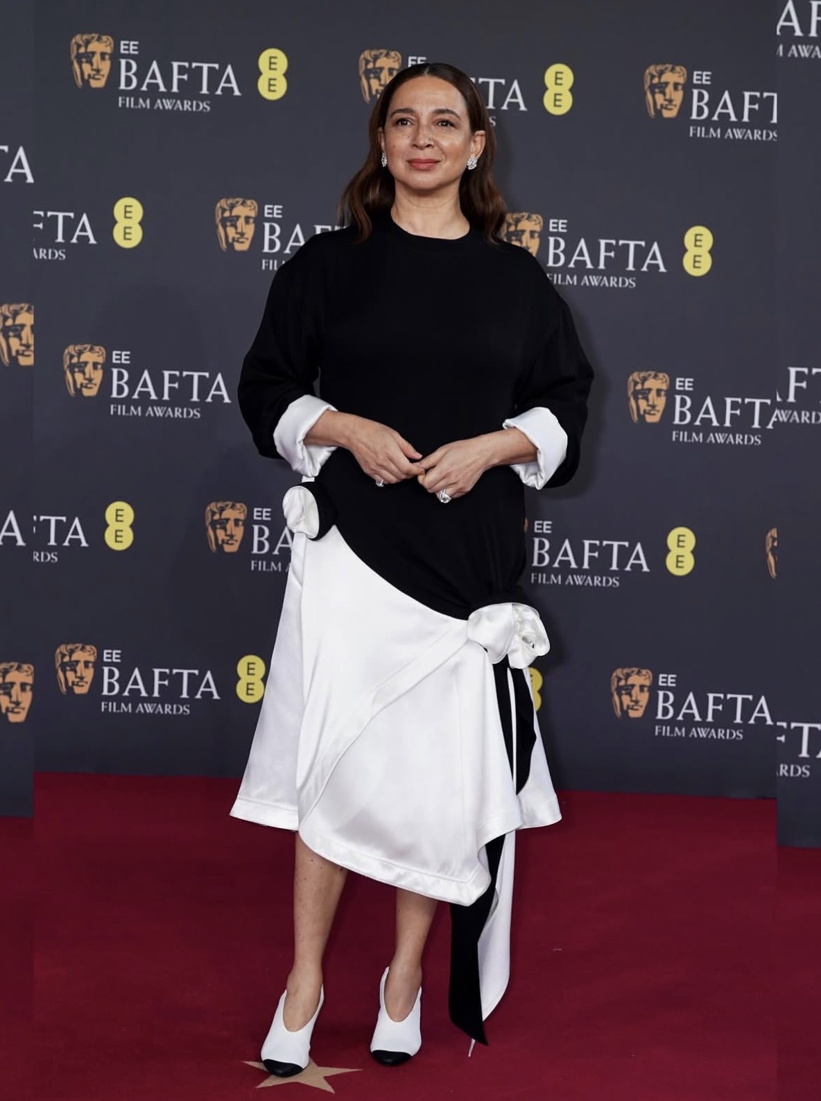 Maya Rudolph in a black-and-white Chanel gown with an asymmetrical skirt and floral appliqués at the 79th British Academy Film Awards — late-winter celebrity outfits