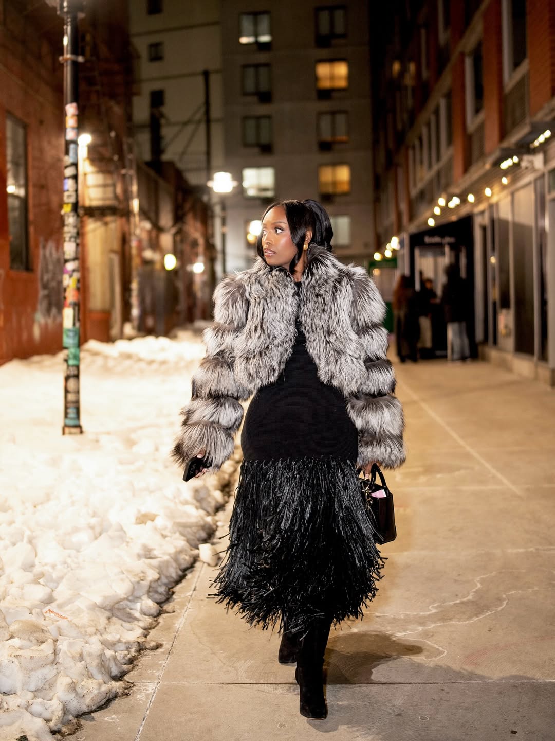 woman wearing a faux fur jacket with fringed skirt
