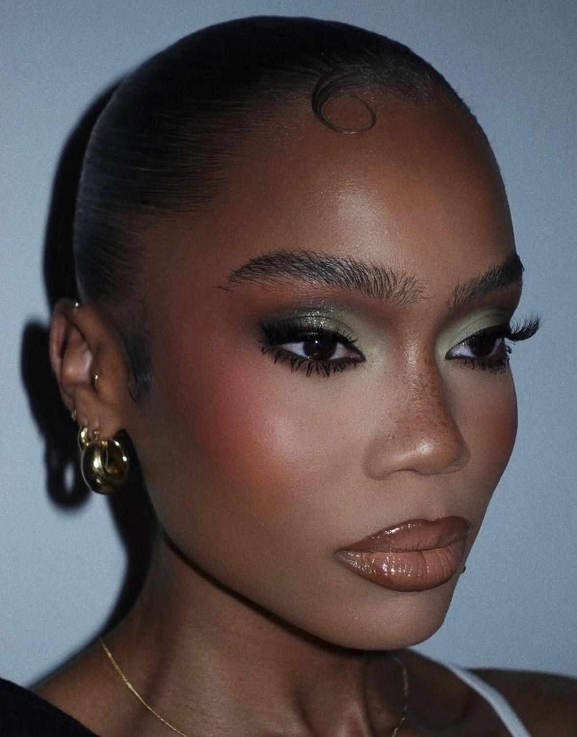 Sage green smoky eye pastel makeup look with winged liner and ombre lips