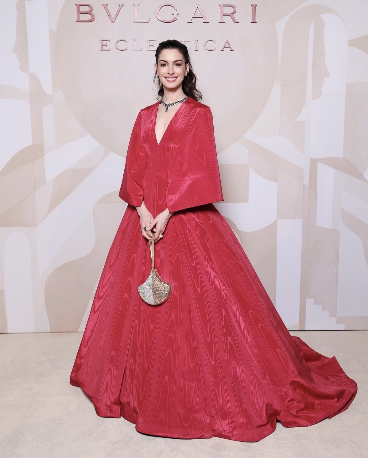 Anne Hathaway in a raspberry Valentino Haute Couture gown styled with a statement sapphire necklace.— celebrity street style fashion 2026