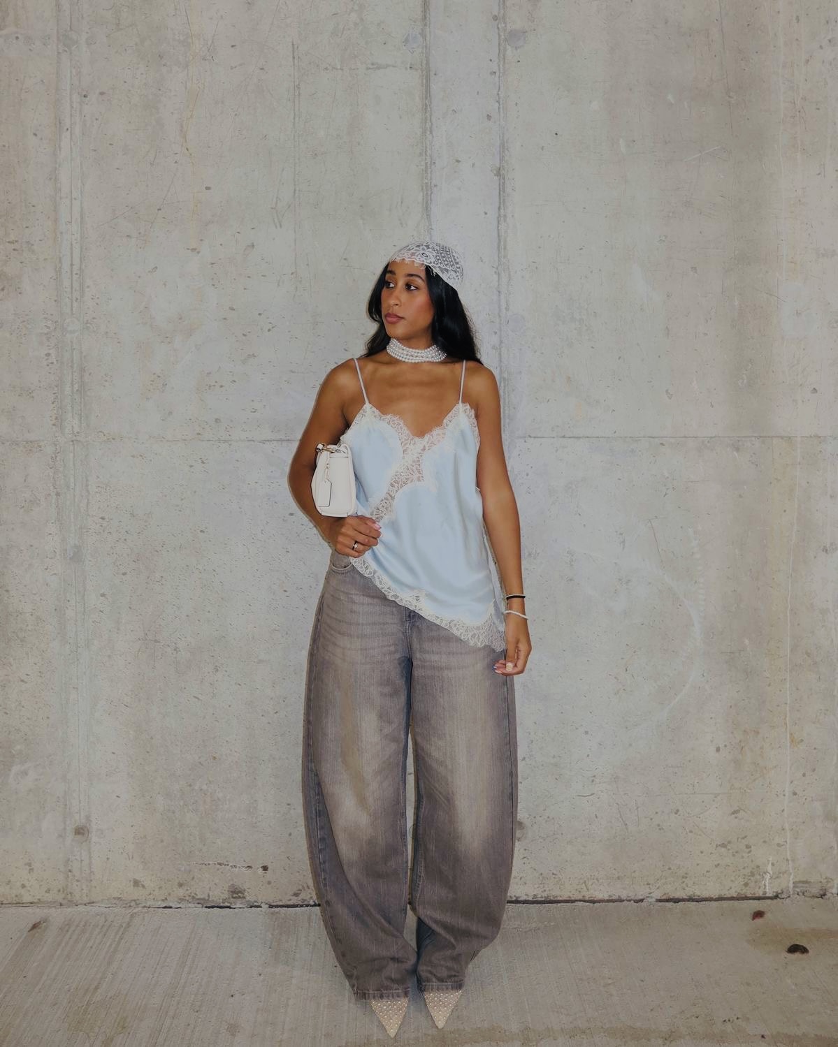 A lingerie slip dress layered over low-rise baggy denim jeans — low-rise baggy jeans women styling