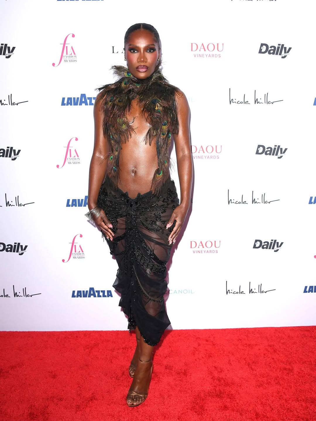 Doechii in a peacock feather Dilara Findikoglu dress at Daily Front Row Fashion Awards 2026.