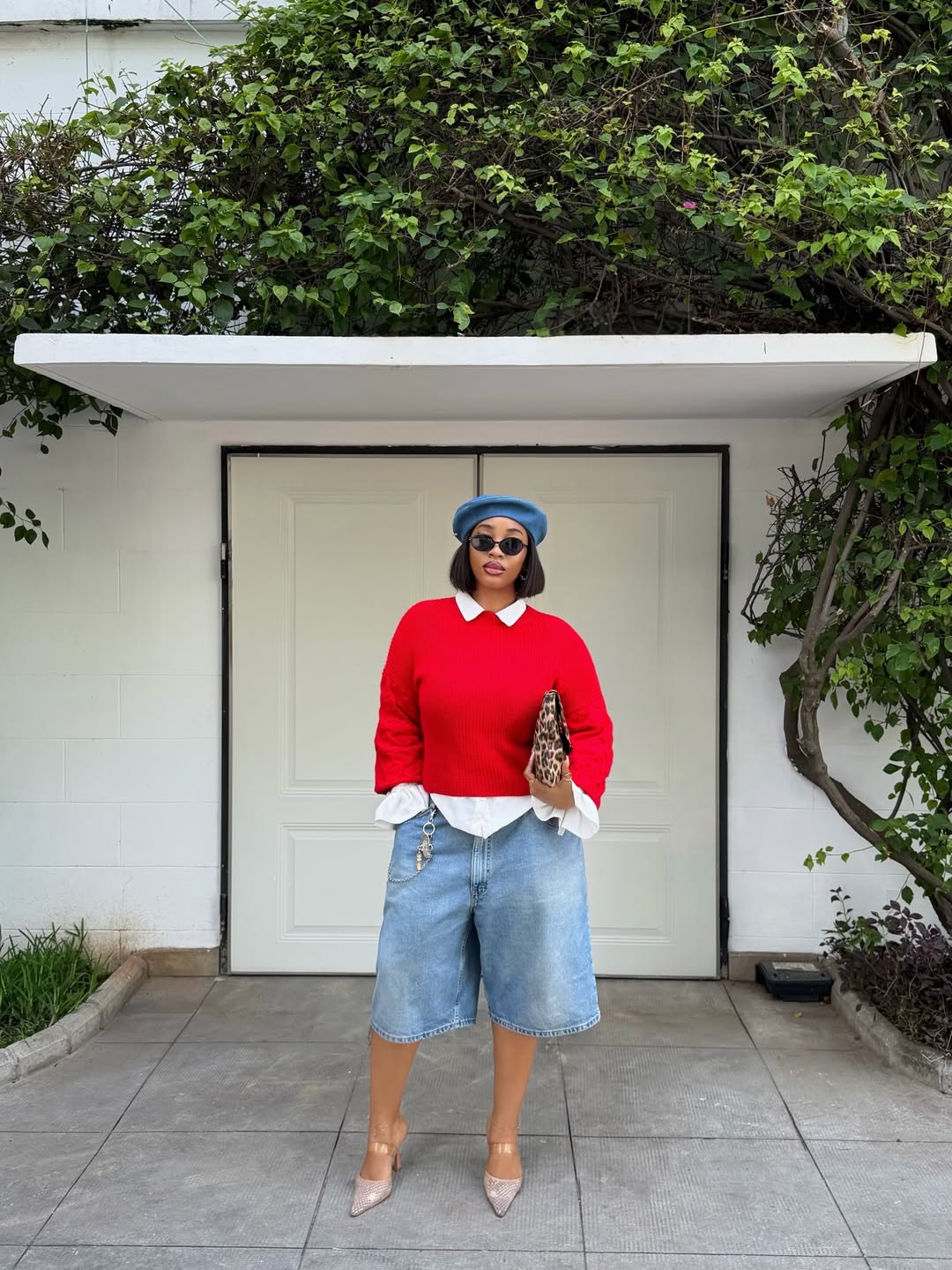 woman wearing light wash denim shorts with red sweater