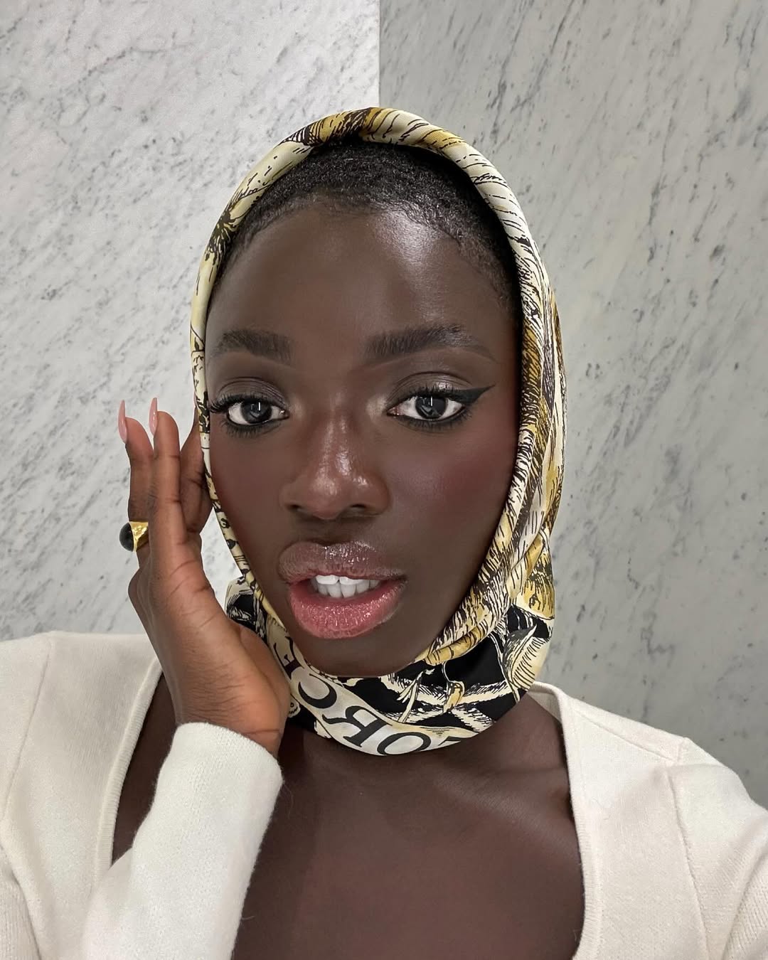 black woman wearing skin tint foundation makeup and a scarf