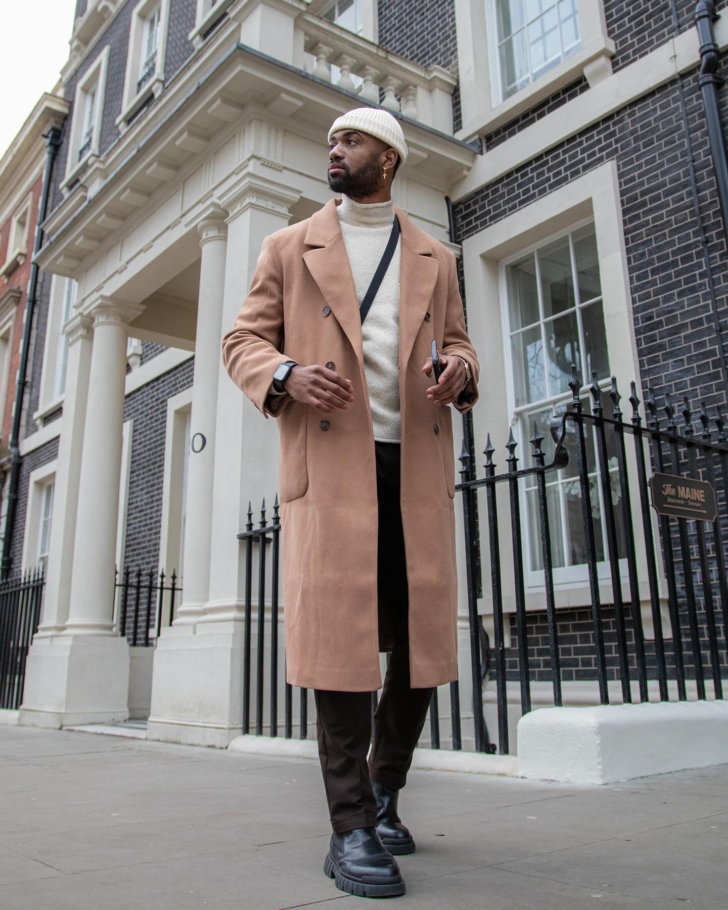 Man in a fine-gauge turtleneck sweater under a camel coat