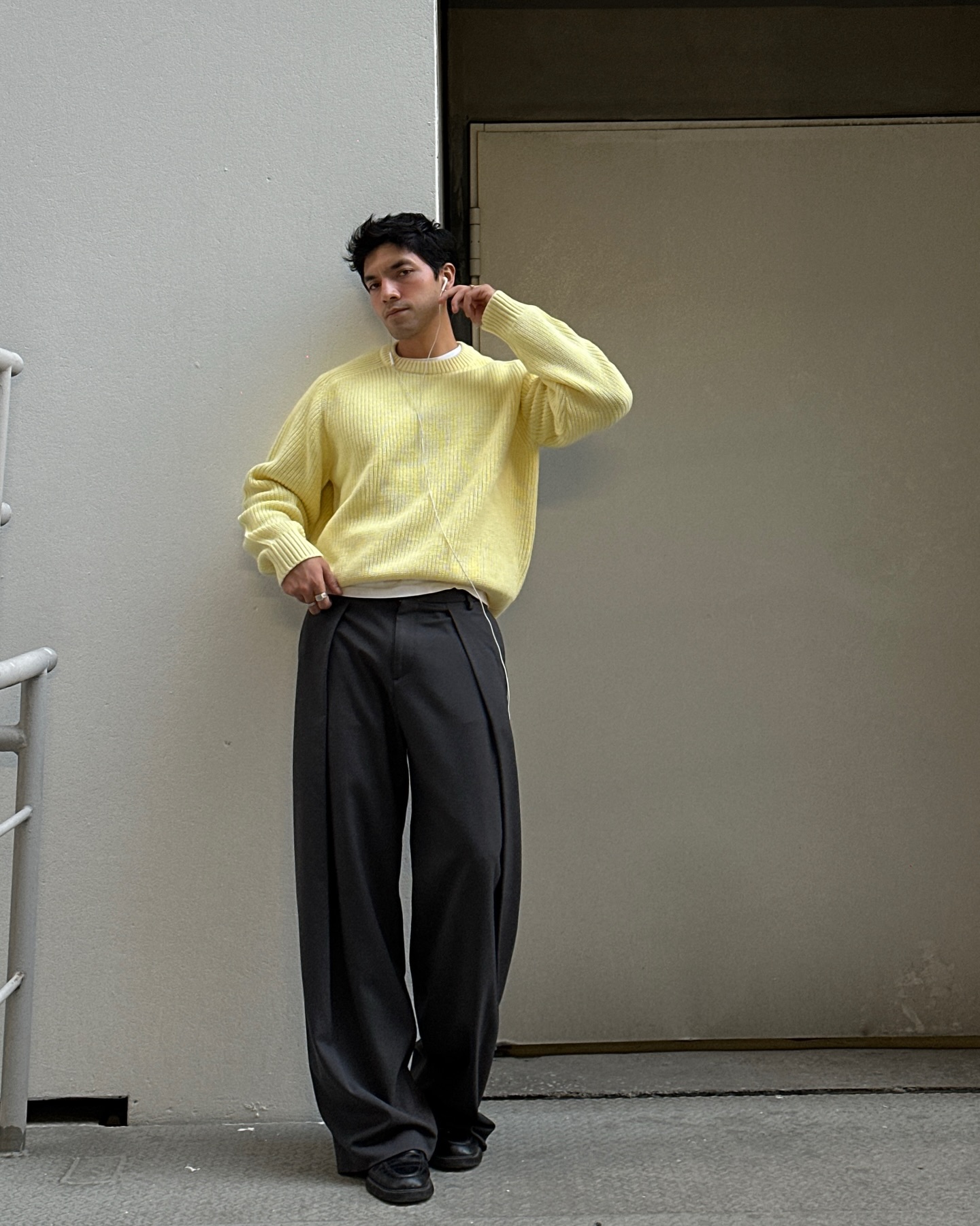 Man in loose pinstripe trousers with a chunky sweater and loafers
