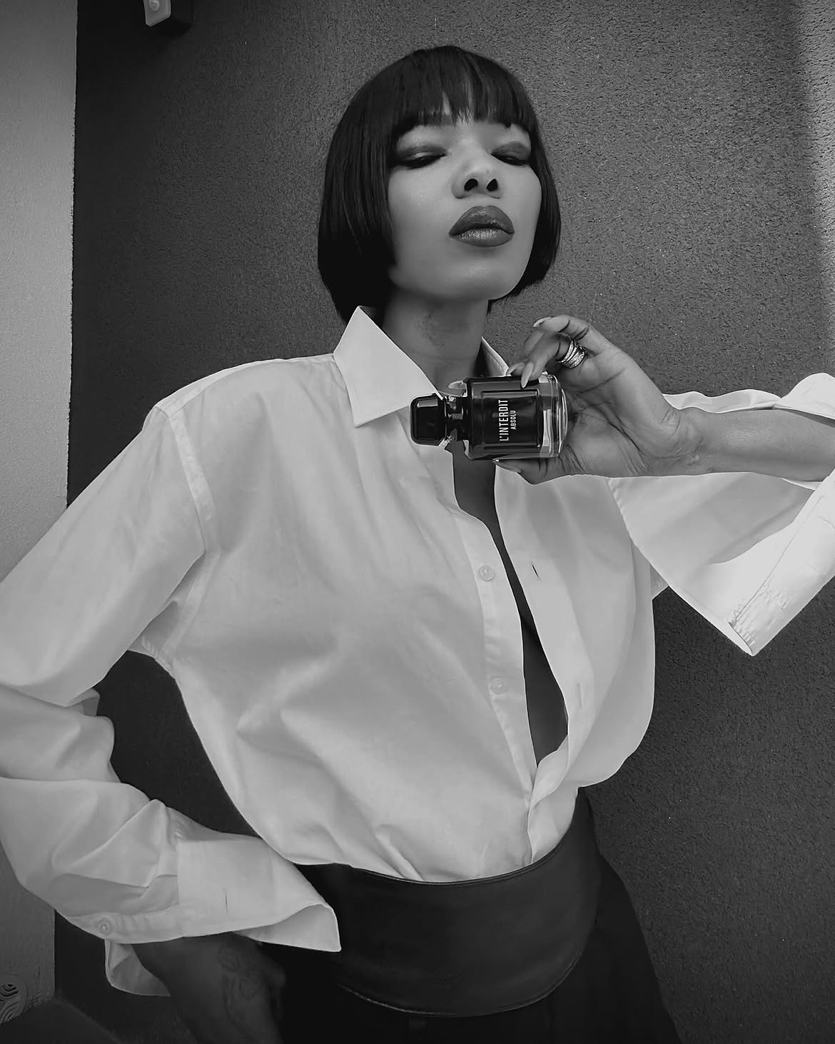 woman holding bottle of perfume personal style